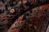 Folds revealing the classic gul ferang motif on the navy and brick red Bijar rug.