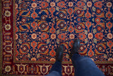 Overhead view of the vintage Russian rug's detailed Herati motif and classic samovar turtle border.
