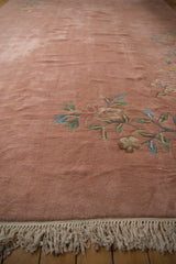 Plush dusty rose pile with detailed floral vines shown above the clean ivory fringe.
