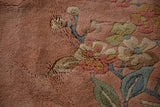 Close-up of the plush, sculpted pile and Art Deco foliage motifs on a vintage dusty rose Japanese carpet.
