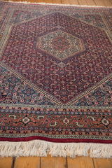 Intricate terracotta, navy, and ivory border of a vintage Indian Bijar with original fringe.