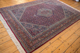Intricate terracotta and navy border detail of vintage Indian Bijar carpet with white fringe.