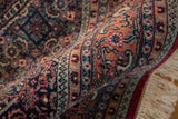 Thick plush pile and intricate Herati motifs on a folded vintage Indian Bijar rug.