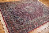 Intact side cord selvage and border with terracotta, navy, and raspberry red motifs.