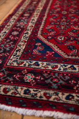 Close view of the vintage Persian rug's full pile and detailed navy and ivory border.