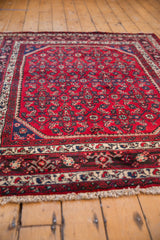 Angled perspective of a vintage Engelas rug's corner, showing its plush red pile and detailed borders.