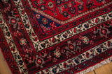 Detail of the original full pile and intricate border on a vintage hand-knotted rug corner.