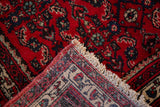 Flipped corner of a vintage Engelas rug showing the hand-knotted back and cherry red pile.