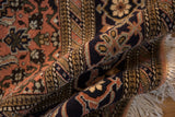 Secured edge of a vintage Ardebil carpet, with deep pile, Herati motif, and ivory fringe.