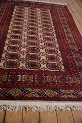 Indian Bokhara gul medallions in cherry red and ivory with geometric border.