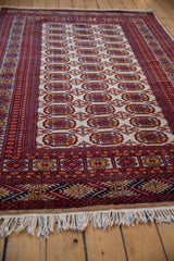 Vintage Indian Bokhara rug's ivory fringe with geometric red, gold, and navy border.