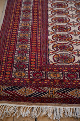 Ivory fringe and geometric border design in cherry red, navy blue, and gold.