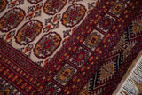 Cherry red and navy geometric patterns on a vintage Indian Bokhara rug with white fringe.