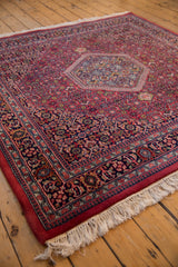 Hand knotted Indian Bijar rug corner with thick raspberry red pile and white fringe.