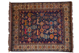 A vintage Indian Shiraz design carpet with a dense allover pattern of colorful animal motifs on a deep blue ground.