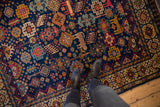 Overhead view highlighting the colorful animal and floral motifs on a vintage Indian Shiraz design carpet.