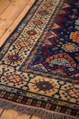 Geometric ivory and blue border detail on the corner of a hand-knotted vintage Shiraz rug.