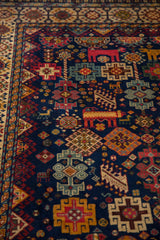 Dense hand-knotted pile of a vintage Shiraz design carpet with colorful geometric and animal figures.