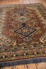 Hand-knotted fringe and intricately patterned border featuring rust, beige, and blue tones.