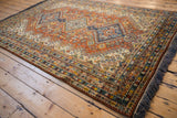 Intact navy blue fringe and geometric border on a vintage Indian Shiraz design carpet corner.