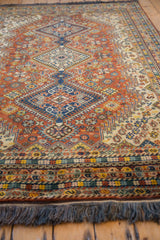 Securely finished fringe and intricate gold, blue, beige geometric border of the vintage rug.