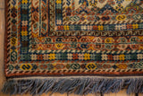 Intricate brown, gold, and blue patterned borders, intact selvage, and blue fringe.