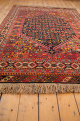 Low perspective on the vintage Afshar carpet's full pile, detailed borders, and natural fringe.