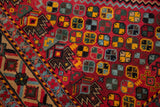 Close-up of the vintage carpet's full pile, showing geometric patterns in red, blue, and gold.