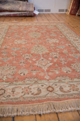 New production Indian Mahal carpet featuring terracotta field, ivory floral palmettes, border, and fringe.