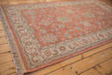 Indian Mahal rug corner, pale terracotta field with ivory border and slate blue floral palmettes.