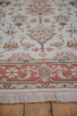 Hand-knotted Indian Mahal rug with ivory field, oversized floral palmettes, terracotta border, and fringe.
