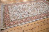 Pale terracotta border with ornate floral patterns on an ivory Mahal rug.