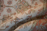 Woven texture showing pale terracotta, ivory, and sea foam motifs on a Mahal rug fold.
