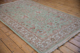Hand woven Indian Mahal carpet with seafoam field, quatrefoil floral palmettes, terracotta borders.