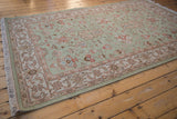Seafoam green hand woven Indian Mahal rug corner with intact fringe and terracotta floral border.