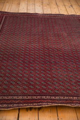 The finely woven, repeating gul pattern across the field of a vintage Afghani Beljic rug.