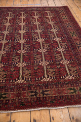 Cherry red Pakistani Belouch rug detail with beige geometric motifs and ivory fringe.