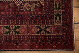 Cherry red and navy Belouch rug corner, with detailed botehs and secure selvage.