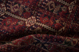 Cherry red and navy vinery and botehs on hand knotted Belouch rug pile.