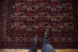 Geometric Belouch rug pattern featuring stylized plants in cherry red, charcoal navy, and beige.