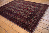 Cherry red and charcoal navy botehs, germinating plants on a Pakistani Belouch rug.
