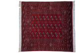 Vintage Pakistani Bokhara square rug with repeating gul medallions in a cherry red, navy, and ivory palette.