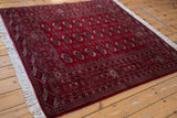 Lustrous cherry red pile of a fine Pakistani Bokhara rug with traditional repeating gul motifs.