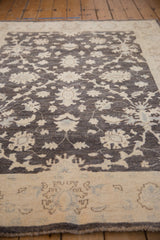 A detailed view of the hand-knotted pile, showing ivory palmettes on a charcoal field.