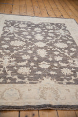 Angled view across the full, hand-knotted pile of a Peshawar rug's charcoal floral pattern.