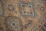 Fine wool pile with blue geometric motifs and soft abrashes on a Pakistani Caucasian rug.