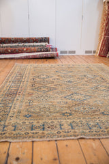 Intact beige fringe and geometric blue-ivory pattern on the rug's secured end.