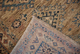 Folded Pakistani Caucasian rug showing hand-knotted pile, geometric motifs, and tonal shifts.