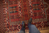 Vibrant geometric cherry red and indigo motifs on the textural wool pile of the rug.