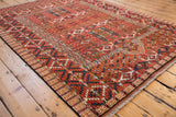 Intricate cherry red, indigo navy, and ivory geometric patterns on this Turkmen design rug.